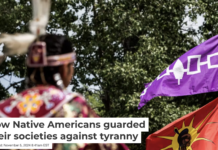 A purple and white flag representing the world’s oldest democracy, the Haudenosaunee Confederacy, flies above a Mohawk flag at a Native American gathering. Giordanno Brumas/SOPA Images/LightRocket via Getty Images